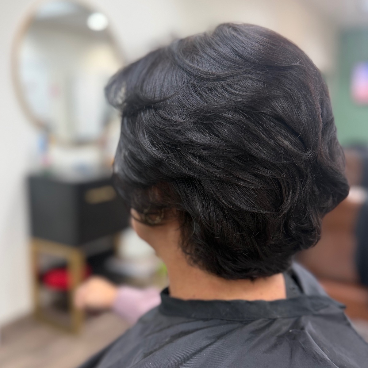 Karen braiding a client's hair for an updo